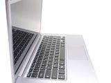 a silver laptop with a black keyboard on a white surface