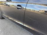 a close up of a car door handle with a reflection of a building in the background