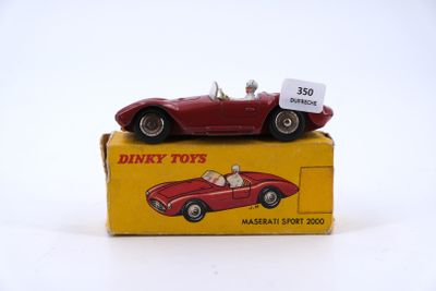 a red toy car sitting on top of a yellow box