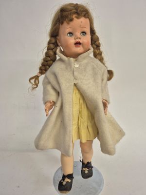 a small doll that is wearing a coat and shoes
