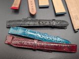 several pieces of leather watch bands are laid out on a table