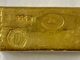 gros plan d'un lingot d'or sur une surface blanche