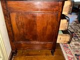 a wooden cabinet in the middle of a room with a rug on the floor