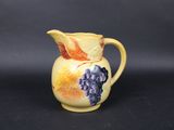 an image of a yellow pitcher with grapes painted on it