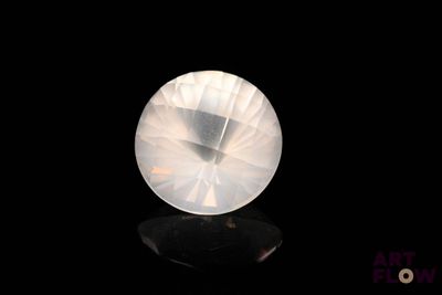 an image of a white crystal stone on a black surface