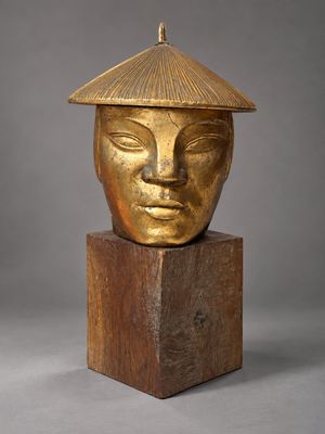 an image of a gold colored sculpture of a woman ' s face