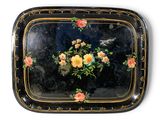 un plateau noir orné de fleurs jaunes et roses