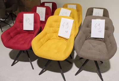 plusieurs chaises de différentes couleurs, munies d'étiquettes de prix, disposées dans une pièce