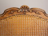 an old wooden chair with a wicker back and a wooden frame