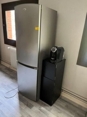 a silver refrigerator and a black refrigerator freezer in a room