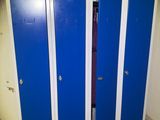 several blue lockers are lined up in a row in a bathroom