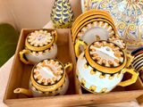 un plateau sur lequel se trouvent une théière, des tasses et des assiettes