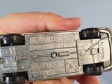 a person holding a silver toy car in their hand