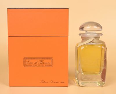 an orange box with a small bottle of perfume next to it