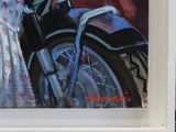 a painting of a motorcycle on display in a white frame