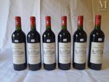 six bottles of wine are lined up on a table