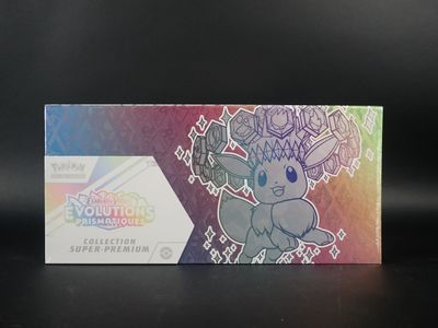 Quelqu'un tient une boîte de cartes à collectionner Pokémon posée sur une table.