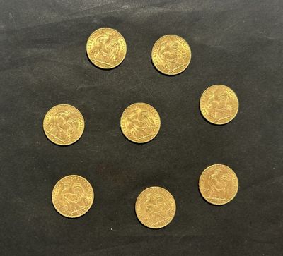 six pièces d'or sont disposées en cercle sur une surface noire
