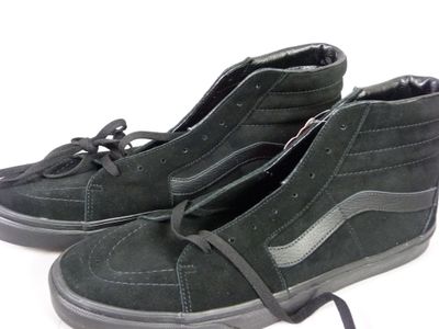 une paire de chaussures noires posées sur une surface blanche