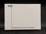 un ordinateur portable Apple posé sur une boîte blanche