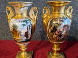 two vases that are sitting on a red cloth