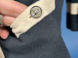 a close up of a person ' s hand holding a button on a jacket