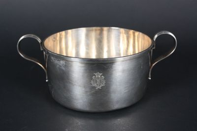 an old silver pot with handles on a black background