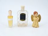 a small bottle of perfume next to a small angel figurine