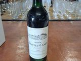 une bouteille de vin posée sur une table, avec des verres en arrière-plan