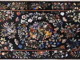 une image représentant un tapis noir orné de fleurs et de feuilles