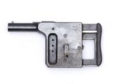 un vieux pistolet posé sur une surface blanche