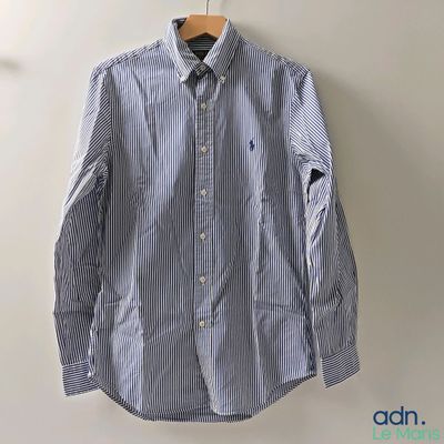 une chemise rayée bleue et blanche accrochée au mur