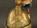a gold helmet with a feather on top of it