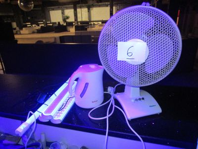 un ventilateur posé sur un comptoir, à côté d'une télécommande
