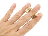 a woman ' s hand with two gold rings on it