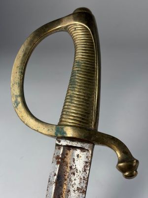 une vieille épée à la poignée dorée sur fond gris