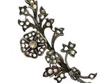 un gros plan d'une broche en forme de fleur ornée de perles