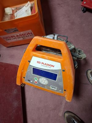a small orange machine sitting on the floor next to other items