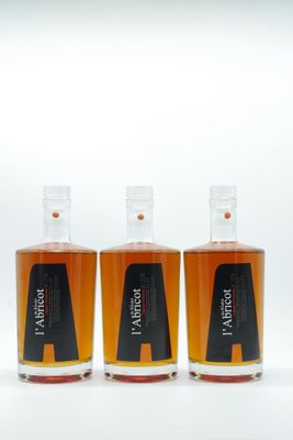 three bottles of whiskey sitting next to each other on a white surface
