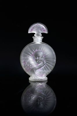 an image of a glass perfume bottle on a reflective surface