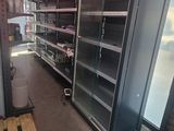 many empty shelves in a store with red lights
