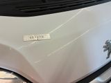 the front end of a white truck with a sticker on it ' s hood