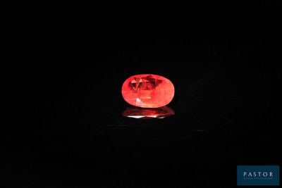 a close up of a red light shining on a black surface