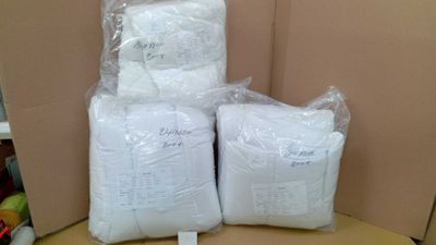 several bags of food are stacked on top of a cardboard box