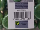 many green marbles in a glass bowl with a price tag