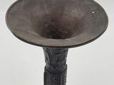 a metal vase that is sitting on a white surface
