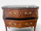 une petite commode surmontée d'un plateau en marbre