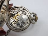a person holding a pocket watch with a chain around it