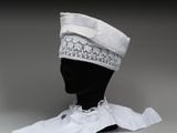 chapeau blanc orné de dentelle et d'un ruban, posé sur la tête d'un mannequin