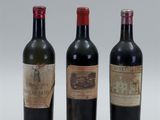 three bottles of wine are lined up on a white surface